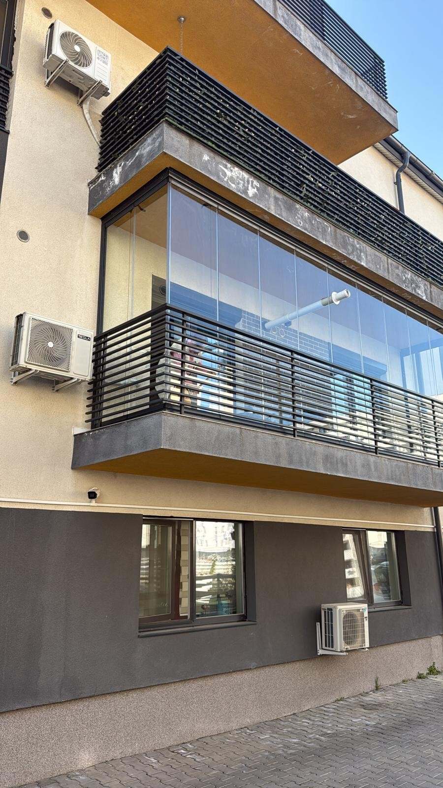 Bloc de locuințe cu un balcon închis cu sticlă armonică la etajul întâi