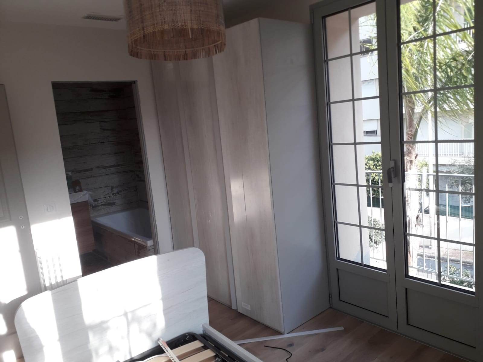 Ușă franțuzească din aluminiu gri cu două canate spre balcon, cu panou plin jos și geam cu șprosuri sus, lângă un dulap
