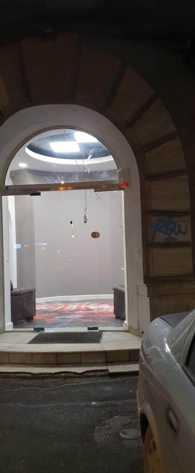 Arcada de la intrarea spațiului comercial de la intersecția Bd. Moșilor cu Bd. Carol, cu ușa din sticlă securizată, văzută de pe trotuar